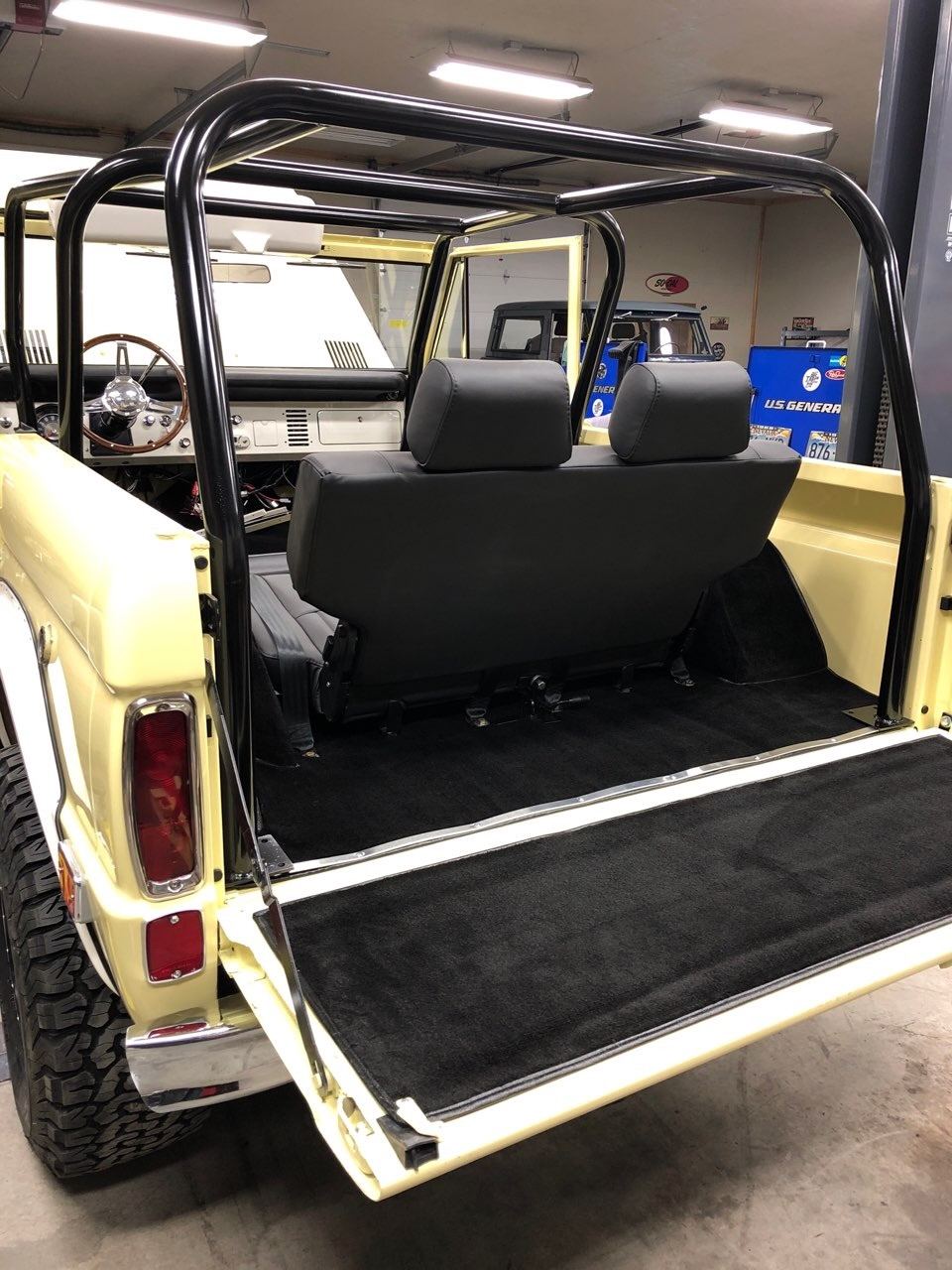 Rear cargo area with tailgate open showing new black carpeting