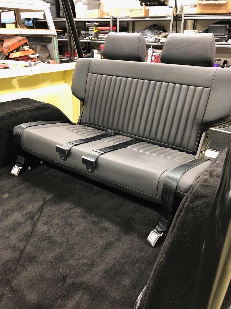 Upholstered black rear bench seat over new black carpeting