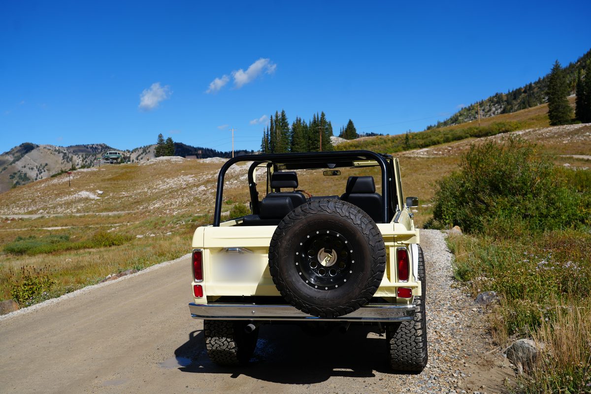 Straight-on rear view with the spare tire, chrome rear bumper and roll cage